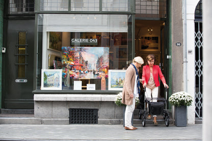 Zwei Frauen mit dem Sunrise Gemino 60 Outdoor Rollator vor einer Galerie in der Altstadt