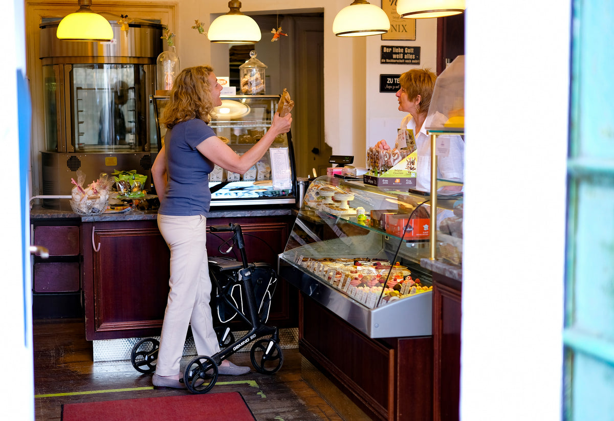 Sunrise Gemino 30 Carbon Rollator beim Einkauf in einer Konditorei