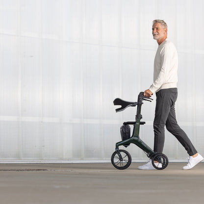 Mann geht mit dem Aero Walk Carbon Rollator in British Racing Green spazieren